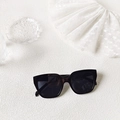 Flat lay of square black sunglasses on white lace and crystal textured background - Classic Black