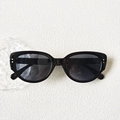 Dettaglio occhiali da sole cat-eye neri con rivetti argentati e lenti grigio scuro - Montatura Nera Lenti Grigie