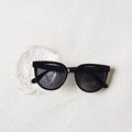 Detail of minimalist black full frame sunglasses with UV400 lenses on a textured tray - Black and Gray