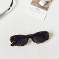 Modieuze cat-eye zonnebril met schildpadmotief en donkere glazen op witte achtergrond - Luipaardprint
