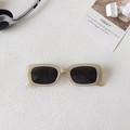 Occhiali da sole quadrati retrò con montatura beige e lenti grigie su sfondo minimalista - Bianco Gelatina Lenti Grigie