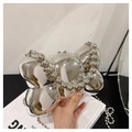 Silver mirror finish bow-shaped clutch with beaded chain strap held in hand - Mirror Silver / Bead Handle Style