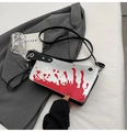 Silver metallic crossbody bag with red splatter pattern on gray blazer background - Silver