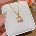 Collier cerise doré avec pendentif en zircon rose sur coussin à bijoux blanc - Acier Titane X256 - Conservation De L'or