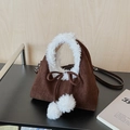 Detail of dark brown faux suede handbag with white plush trim handles and fuzzy pom-poms - Coffee