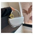 Close-up of silver crescent handbag with golden metal ring and leather strap details - Silver
