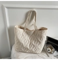 Détail du sac cabas matelassé avec texture à motifs S et étiquette près du casque - Blanc Cassé