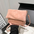 Borsa a sella rosa opaco con zip metallica e tracolla mostrata tenuta in mano - Taglia unica / Rosa