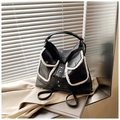 Détail du sac à dos en cuir noir avec bordure en polaire blanche et bouton métallique - Noir