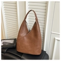 Detailed close-up of brown leather texture and stitching on large hobo shoulder bag - Brown