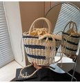 Detalle del bolso tipo cubo de paja con lazo de encaje y cierre de cordón ajustable - Azul