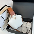 Bolso tipo cubo de cuero blanco y marrón con broche dorado en una caja de regalo negra - Blanco