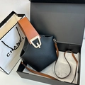 Bolso cubo negro con textura litchi, asas marrones y cierre dorado en G sobre caja - Negro
