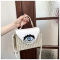 Detail der weißen geflochtenen Box-Tasche mit blauem Evil Eye-Perlen- und Quastendekor - Gebrochenes Weiß