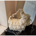 Detailed view of cream ruched cloud bag with soft pleats on a black wooden table - Off-white