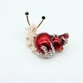 Macro detail of snail brooch with red enamel shell and sparkling crystal rhinestones - Red