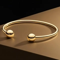 Minimalistische gouden titanium stalen armband met gepolijste metalen bollen aan de uiteinden - Kogel Open Armring / Goud