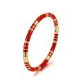 Detailansicht eines goldfarbenen Armreifs mit roter Emaille und Streifenstruktur - Rot