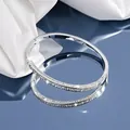 Detail of silver stainless steel bangle with polished finish and micro-pave diamond texture - Rhinestone Inlaid Style (44-D-10) / Steel Color (44-D-10)