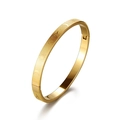Dettaglio bracciale dorato con incisioni di sole e luna e finitura opaca testurizzata - Oro