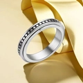Macro shot of silver rotating ring with brushed metal texture and black dot pattern - Dot Pattern Spinner Style