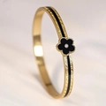 Detailed close-up of golden bangle featuring a black clover motif and zircon inlay - 6mm Width / Black