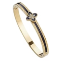 Dettaglio del bracciale dorato con motivo a greca e quadrifoglio di zirconi - Trifoglio Nero (con Strass)