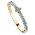 Dettaglio del bracciale dorato con quadrifoglio in smalto blu, zirconi e greca incisa - Trifoglio Blu Chiaro (con Strass)