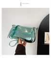 Macro shot of metallic light blue shoulder bag with glossy mirror finish and silver buckle - Blue