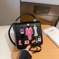 Black quilted crossbody bag featuring colorful fashion patchwork embroidery and silver hardware - Black