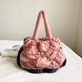 Pink quilted puffer tote bag featuring soft pleated nylon and adjustable black shoulder strap - Pink