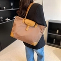 Borsa tote in nylon marrone con finiture in pelle e tracolla in una scena lifestyle - Cachi