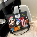 Black leather tote bag with colorful London-style patches and adjustable shoulder strap - Black