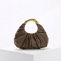Macro view of brown ruched handbag featuring a vintage gold bamboo-style metal handle - Brown