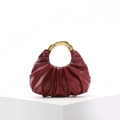 Detail of burgundy pleated leather bag featuring a modern gold circular metal handle - Burgundy