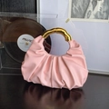 Rosa geraffte Cloud-Bag mit elegantem goldenem Ringgriff auf luxuriösem schwarzem Holz - Rosa