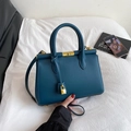 Sac à main élégant en cuir bleu foncé avec détails dorés et poignée sur tissu blanc - Vert