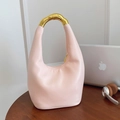 Borsa a mezzaluna rosa pallido con manico in metallo dorato su tavolo scuro - Rosa