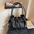 Minimalistische schwarze Leder-Eimertasche mit Kordelzug und Stern-Anhänger-Detail - Schwarz