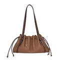 Large tan leather drawstring bucket bag with a floral charm and dark brown shoulder strap - Mocha