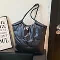 Detail der schwarzen Stepptasche mit Sternbestickung und geflochtenen Seilgriffen - Blau