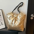 Macro detail of metallic gold tote bag featuring star embroidery and rope handles - Gold