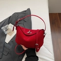 Minimalist red leather crescent handbag with silver metal lock and adjustable strap - Burgundy