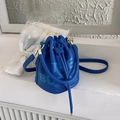 Detail of royal blue leather bucket bag with The Bucket text and gold hardware - Dark Blue