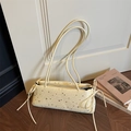 Borsa baguette crema con stelle nere stampate e fiocchi laterali su pavimento in legno - Giallo