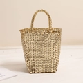 Chic gold woven basket bag with a metallic finish and stylish top handles for beach holidays - Gold