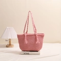 Pink hand-woven cotton shoulder bag with tassel details on a minimalist pedestal - Pink