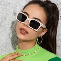 Close-up of white square sunglasses paired with daisy bead necklace and green knitwear - Beige
