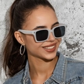 Close-up of retro square gray sunglasses and sparkling rhinestone hoop earrings on model - White