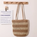 Borsa tote a righe in paglia fatta a mano in marrone e beige appesa a un gancio - Fiore Vuoto Caffè
